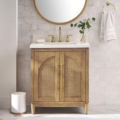 a bathroom vanity with a round mirror above it