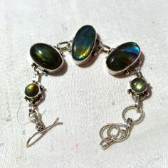 This Is A Beautiful, Multiple Stone, Handmade, Labradorite Bracelet. There Are Five Stones And Each One Gleams In The Light. No Dull Labradorite Here! It Has A Toggle Bar Clasp And Looks Beautiful On The Wrist. I Love It! Sometimes It Is Very Hard Not To Keep The Jewelry I Order To Sell! Haha ;) I Hope You Like This Piece Too. Thanks For Stopping By And Feel Free To Leave Me A Fair Offer. :) Silver Bracelets With Natural Stones And Labradorite, Silver Labradorite Bracelets With Natural Stones, Silver Labradorite Gemstone Bracelets, Silver Labradorite Bracelet With Gemstones, Juicy Couture Charms Bracelet, Arm Cuff Bracelet, Blue Stone Bracelet, Beaded Bangles Bracelets, Hammered Bangles