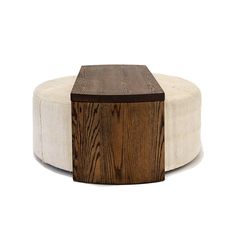 a wooden box sitting on top of a white tablecloth covered ottoman with wood trim