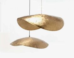 two large metal objects suspended from strings in the air