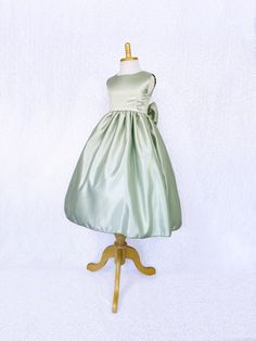 A classic and simple but beautiful full satin dress that's perfect for any formal occasion: weddings, graduations, birthdays, or holidays! Handcrafted with the upmost of care and attention to detail, we make sure that each dress is perfectly one of a kind for your little girl. Comfortable satin material covers the dress from shoulder to hem. The sleeveless top has a zipper on the back for closure. Comes with a detachable matching bow with tails. The skirt has a layer of lining underneath with at Satin Princess Dress With Fitted Bodice For Pageant, Bridesmaid Princess Dress With Satin Bow, Satin Bridesmaid Princess Dress With Satin Bow, Bridesmaid Dress With Satin Bow And Fitted Bodice, Green Satin Finish Bridesmaid Dress, Satin Princess Dress With Satin Bow, Satin Finish Bridesmaid Dress, Satin Princess Bridesmaid Dress, Princess Style Satin Bridesmaid Dress