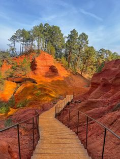 the stairs lead up to an area with red hills in the background and trees on either side