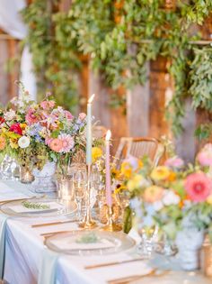 a table with flowers and candles is set up for a formal dinner or wedding reception