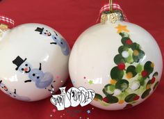 two white christmas ornaments with designs on them