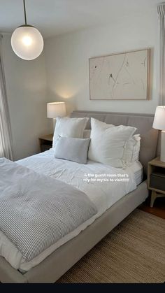 a bed with white sheets and pillows in a bedroom next to two lamps on either side of the bed