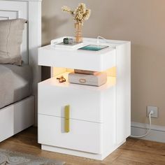 a white night stand with an electronic device on it