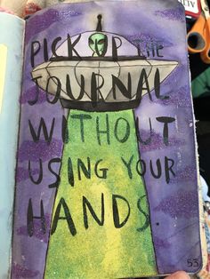 a hand holding up a book with writing on it