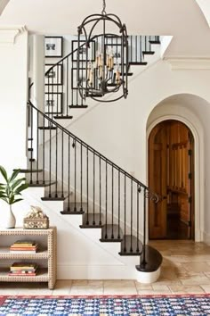 an entryway with a chandelier and rug on the floor