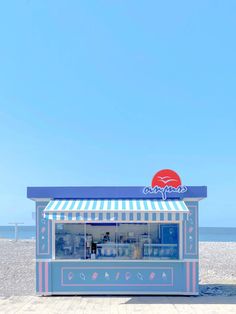 a blue and white striped kiosk on the beach