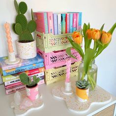 there are many books and vases with flowers on the table next to each other