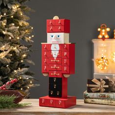 a wooden toy soldier standing in front of a christmas tree with presents on the table