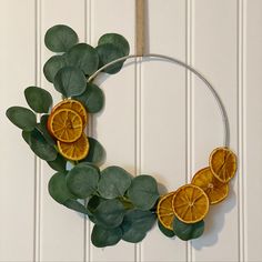 an orange slice and leaf wreath hanging on a wall