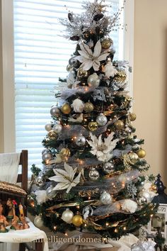 a decorated christmas tree in a living room with white and gold ornaments on the top