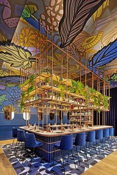 an artisticly decorated bar with blue chairs