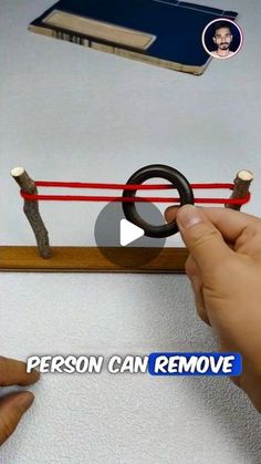 someone is trying to remove an object from the wall with their finger and thumbnails