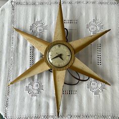 a clock that is sitting on top of a table cloth with a star pattern around it