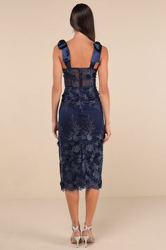 The Lulus Exquisite Charisma Navy 3D Floral Bustier Tie-Strap Midi Dress is the perfect pick for those occasions where you want to look effortlessly lovely! A sheer mesh overlay boasts intricate embroidery and three-dimensional floral appliques as it shapes a bustier-inspired bodice with sheer panels (along with padded cups, no-slip strips, and supportive boning) and a flirty sweetheart neckline, all supported by long satin tying straps. The high, fitted waist tops a figure-skimming column skirt 3d Floral Dress, Floral Bustier, Column Skirt, Corset Bustier, Mesh Overlay, Intricate Embroidery, Floral Applique, Sweetheart Neckline, Appliques