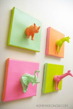 three different colored animal magnets mounted to the side of a wall, each with an elephant and giraffe on it