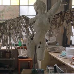 a sculpture is being made in an art studio with lots of work on the table