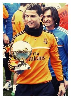 a man in an orange jersey holding a soccer ball