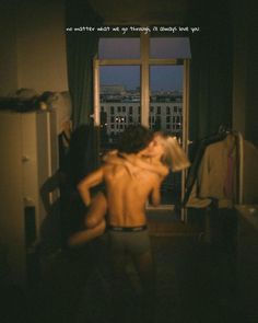 a man standing in front of a window with his back turned to the camera,