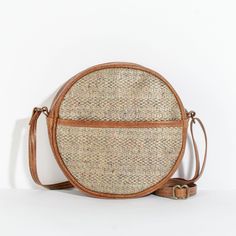 "With it's trendy shape, the Monaco Circle Bag is the perfect size and mix of fabric and leather. Wear it as a crossbody or over the shoulder. This bag is a showstopper. Dimensions: 10\" in diameter x 3\" deep. Strap is adjustable, and is approximately 52\" inches at its max length." Brown Straw Shoulder Bag For On-the-go, Spring Tote Bag With Leather Trim, Fall Travel Crossbody Shoulder Bag, Spring Crossbody Hobo Bag With Adjustable Strap, Beige Shoulder Bag With Leather Trim For On-the-go, Spring Crossbody Shoulder Bag With Adjustable Strap, Spring Travel Bag With Leather Trim, Beige Woven Bags For On-the-go, Spring Leather Bags With Leather Trim