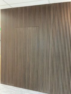 a large wooden wall with vertical slats in an office building or conference room area