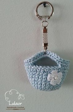 a crocheted keychain with a white flower on the front and bottom