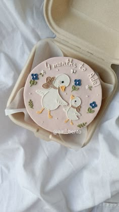 a cake in a box with two birds on it