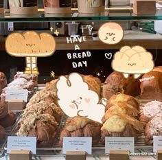 breads and pastries are on display in a bakery case with stickers that say have a bread day