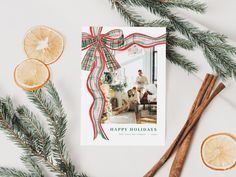 a holiday card with orange slices, cinnamon sticks and an orange slice next to it