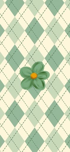 a green flower sitting on top of a checkered tablecloth with an orange center