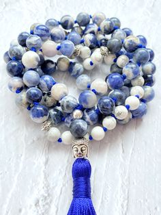 This mala necklace is made with 108 natural stone beads of blue sodalite and white howlite adorned with silver beads. This prayer garland  is the perfect support garland for counting mantras during your practices. Its a 108 knotted beads  violet mala, very light weight, an spiritual sacred jewelry for chakra healing. I make each mala by hand, knotting each of the 108 beads with great care and I made every single silky and delicate tassel. I use a very resistant braided macrame rope, achieving a mala that lasts over time. All our malas are very versatile, since you can use them on many occasions. This prayer garland has two beads size:  - small 6mm.  53 cm / 21 inch - large 8mm.  61 cm / 24 inch Spiritual Stone jewels choose personally every single gemstone for her prayer garlands, to ensur Blue Round Beads Mala For Meditation, Blue Mala With 8mm Beads For Meditation, Blue 8mm Beads Spiritual Mala, Blue Spiritual Mala With 8mm Beads, Spiritual Blue Mala With 108 Beads, Blue Gemstone Beads Mala As Gift, White Hand Knotted Spiritual Jewelry, Braided Macrame, Sacred Jewelry