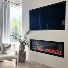 a living room with a large window and a fire place in the wall next to it