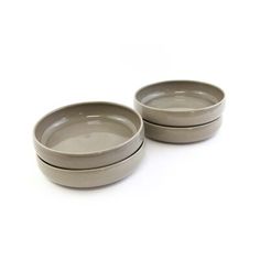 two gray bowls sitting next to each other on a white surface