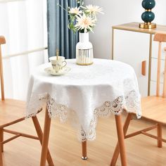 a white table with two chairs and a vase on it