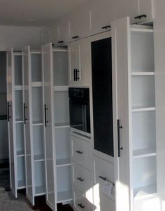 a room filled with lots of white cabinets