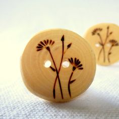 two wooden buttons with floral designs on them