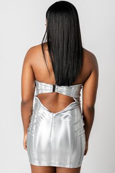 the back of a woman wearing a silver dress