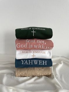 three folded towels with the words god is enough and an image of a cross on it