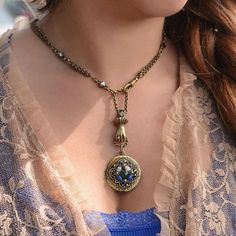 "Loaded with vintage mystique, an exquisite 3-D sculptured hand clutches a rope ring from which the locket is suspended. The locket, made with old dies, has an engraved border. The top is set with oval rose quartz and lapis with a round moss green round stone in the center. The fluid vintage rolo chain has with bar stations set with hematite. It joins the pendant portion with an old swivel. Beautifully detailed and finished in burnished bronze. Size: 16\" L plus 4\" extender. Produced by the han Vintage Clover, Locket Necklace Vintage, Ruby And Diamond Necklace, Victorian Locket, Rope Ring, Victorian Necklace, Good Luck Necklace, Diamond Evil Eye, Jewelry Lockets