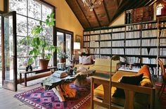 a living room filled with lots of furniture and bookshelves next to a window