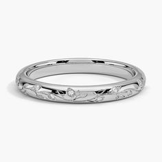 a white gold wedding band with leaves and diamonds on the inside, set in 18k white gold