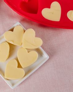 some heart shaped cookies on a plate next to a red tray with hearts in it