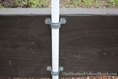 a close up of a white pole with two metal brackets on it's sides