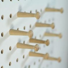 several pegs are arranged on the wall with holes in them