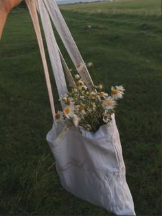 someone is holding a bag with flowers in it