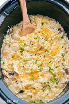 a crock pot filled with chicken and rice topped with parsley in the slow cooker