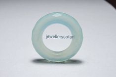 a glass ring sitting on top of a white table next to the words jewelry safari