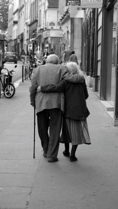 an elderly couple walking down the street